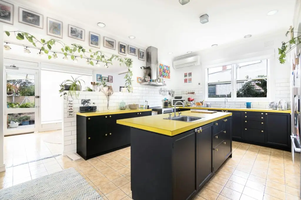Stylish and bright kitchen with yellow countertops and indoor plants in Melbourne, Australia.